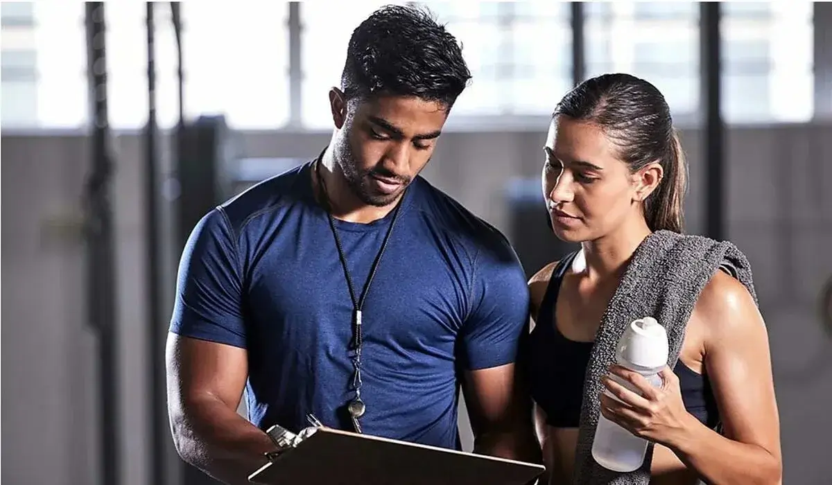 Personal trainer assisting a client