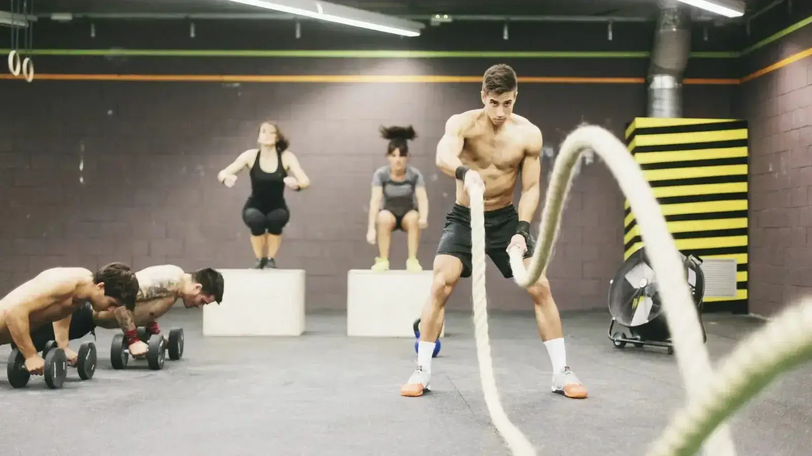 Athletes using battle ropes in a HIIT class
