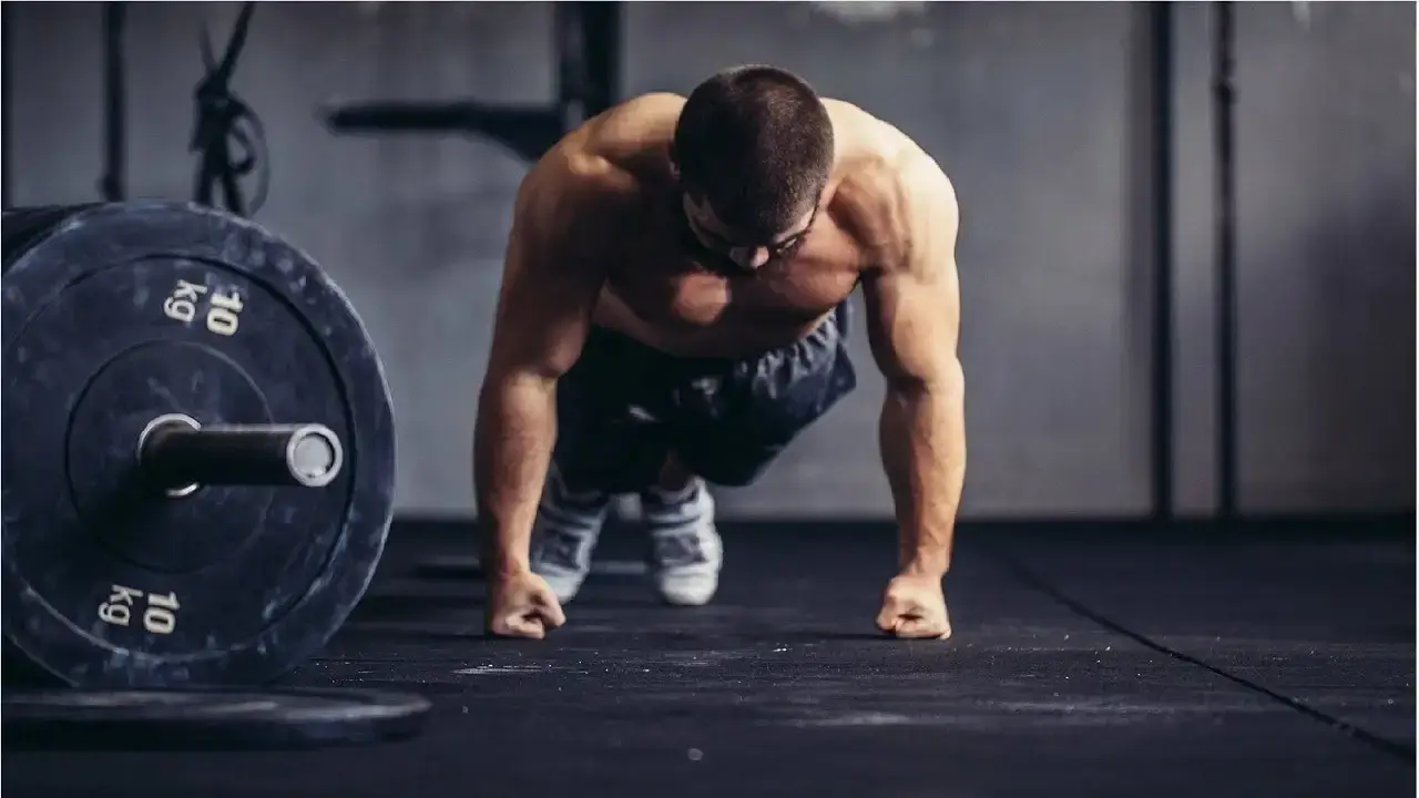 A person lifting a heavy barbell during a strength class